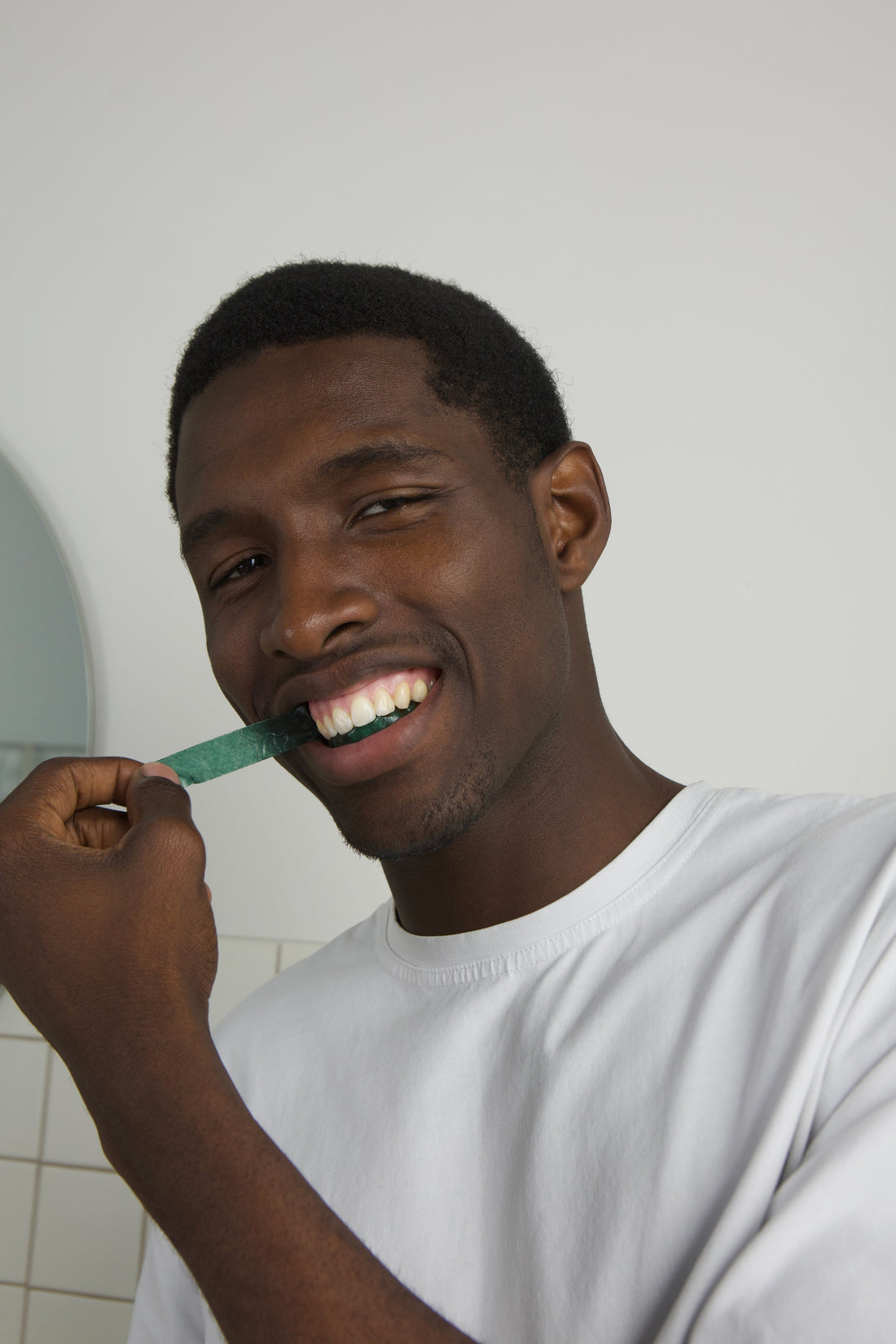 Smiling man brushing his teeth as part of his daily oral care routine