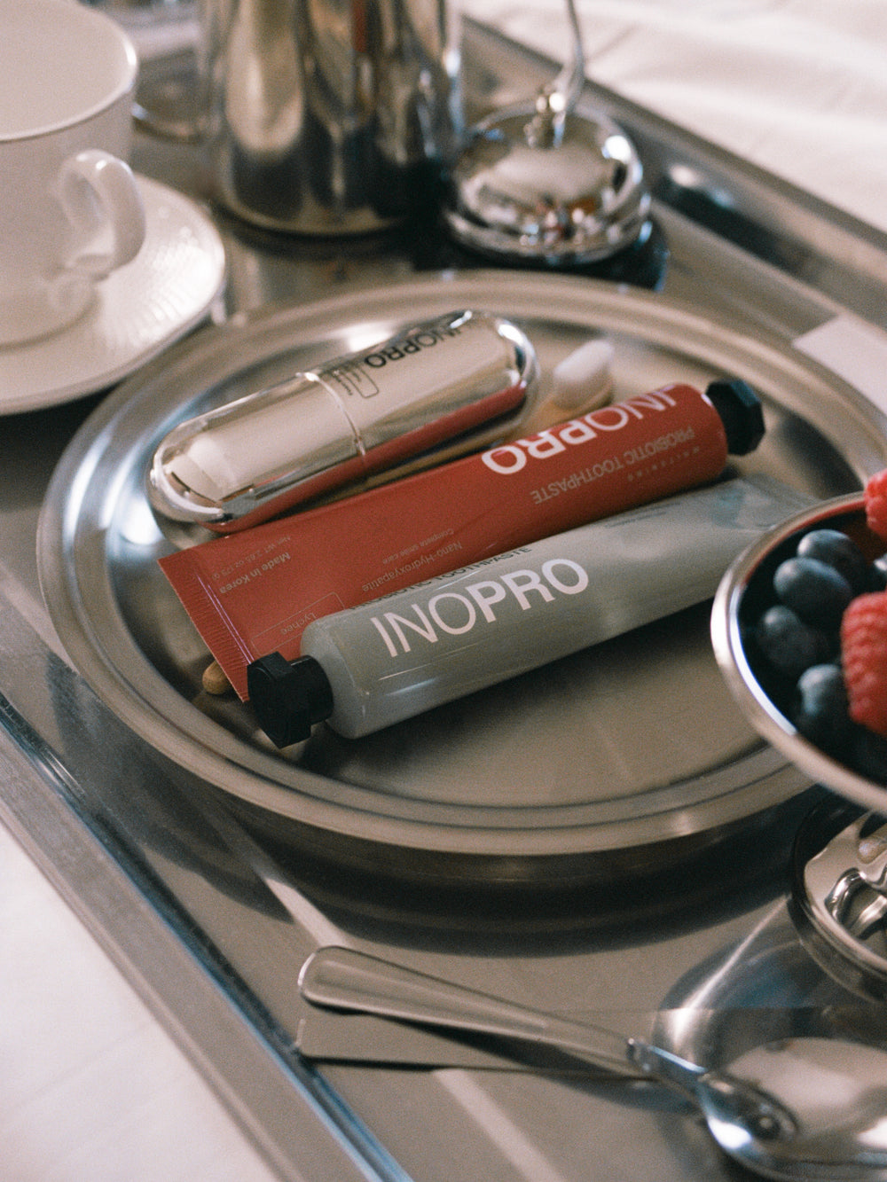 INOPRO toothpaste and foam mouthwash arranged on a silver tray
