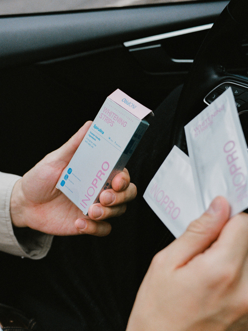 Hands holding INOPRO Innovative and Advanced whitening strips