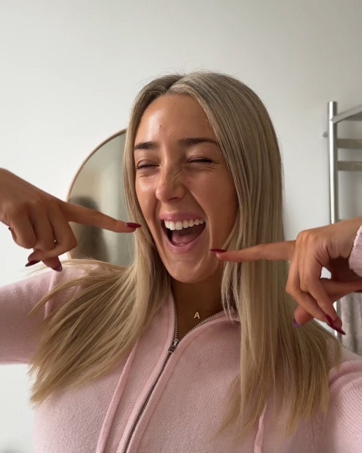 Woman pointing to her smile