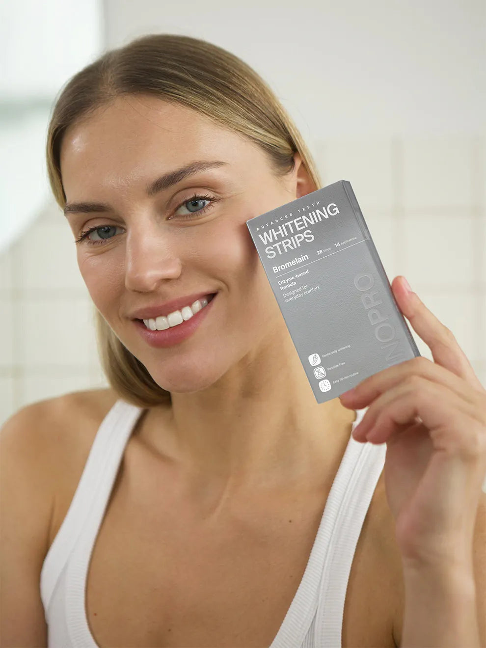Woman holding INOPRO Advanced whitening strips