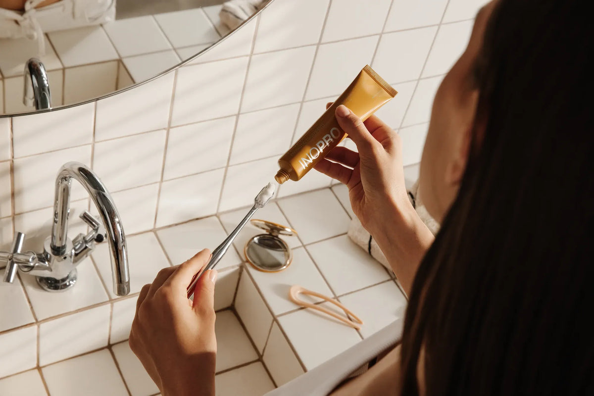 Ginger toothpaste squeezed onto a toothbrush at the sink