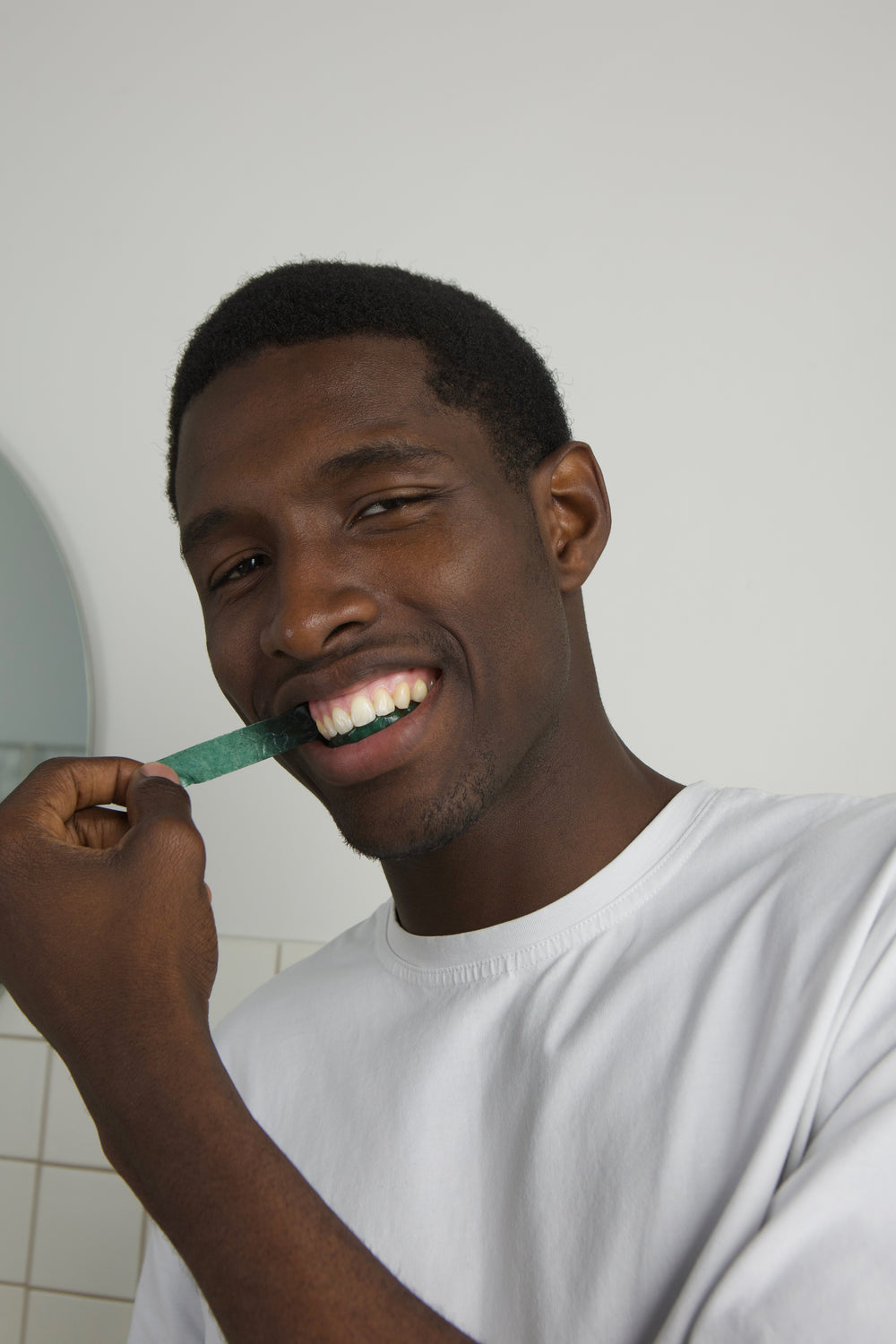 Smiling man brushing his teeth as part of his daily oral care routine
