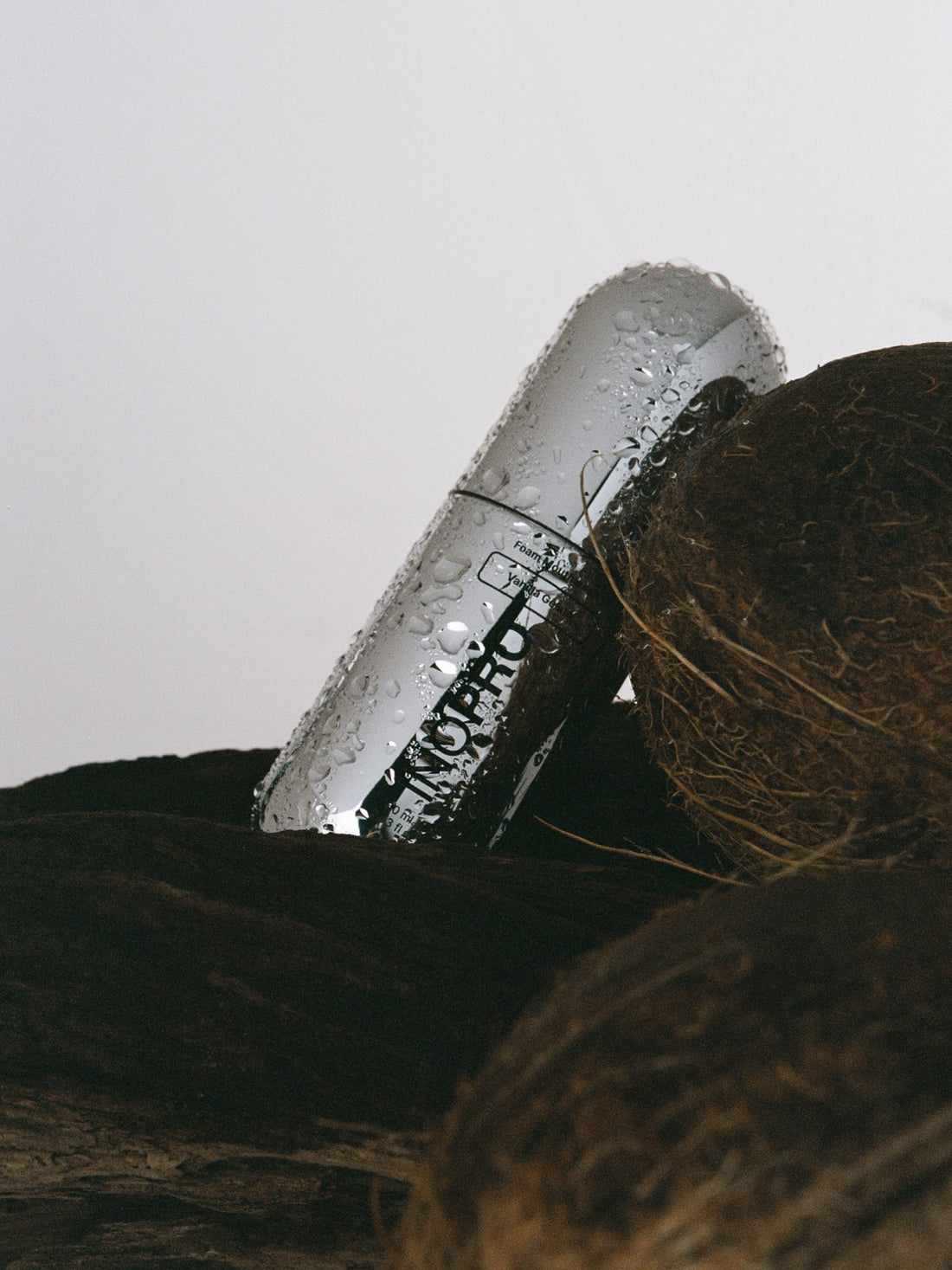 INOPRO foam mouthwash bottle with water droplets beside a coconut