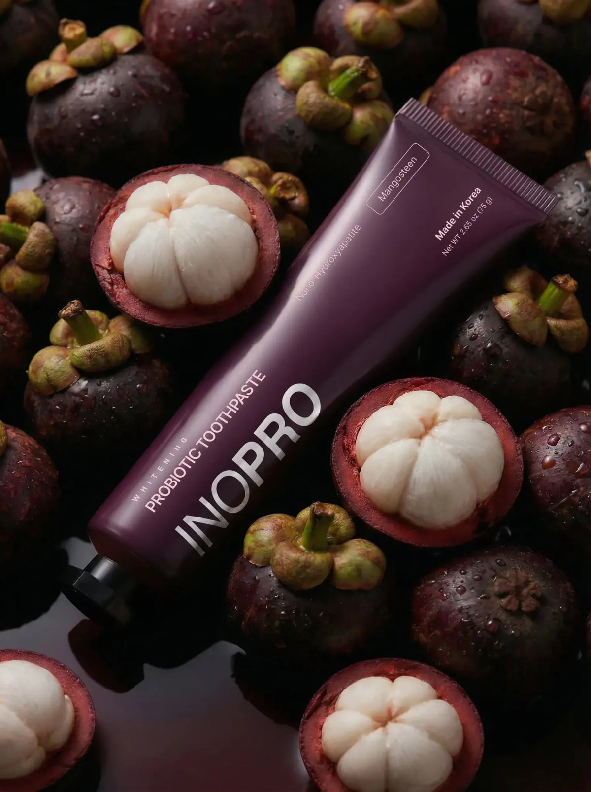 INOPRO Whitening Probiotic Toothpaste Mangosteen plum tube among whole and opened mangosteens
